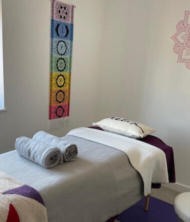 Relaxing treatment room Image of a treatment bed with blankets and cushions in a peaceful room